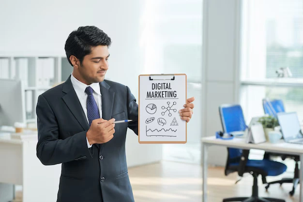 Businessman in a suit presenting a digital marketing plan on a clipboard in an office